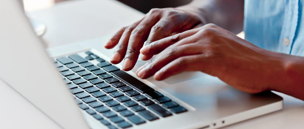 Close-up of hands using a laptop keyboard