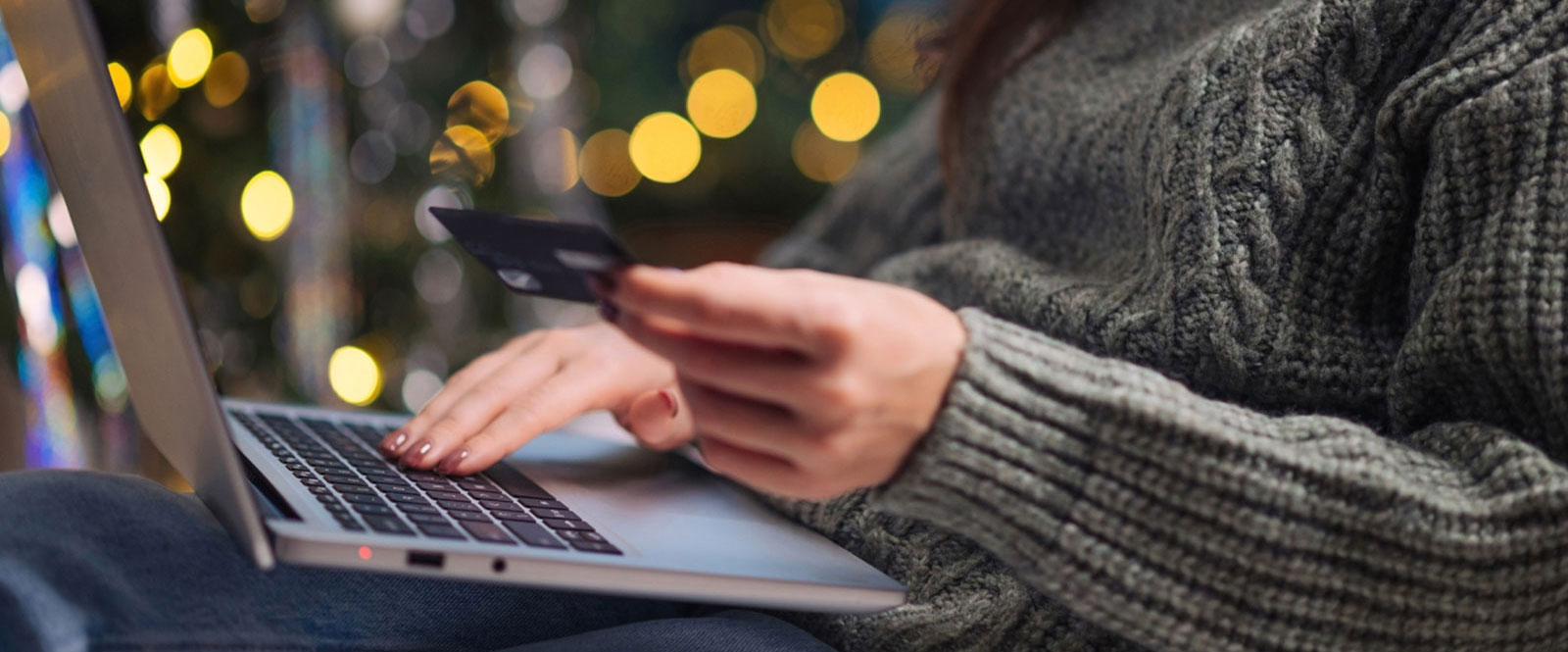 Close up of woman using computer and holding credit card