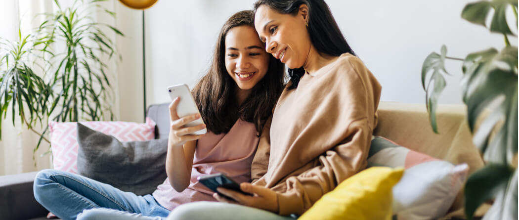 Mom and teenager looking at smartphones