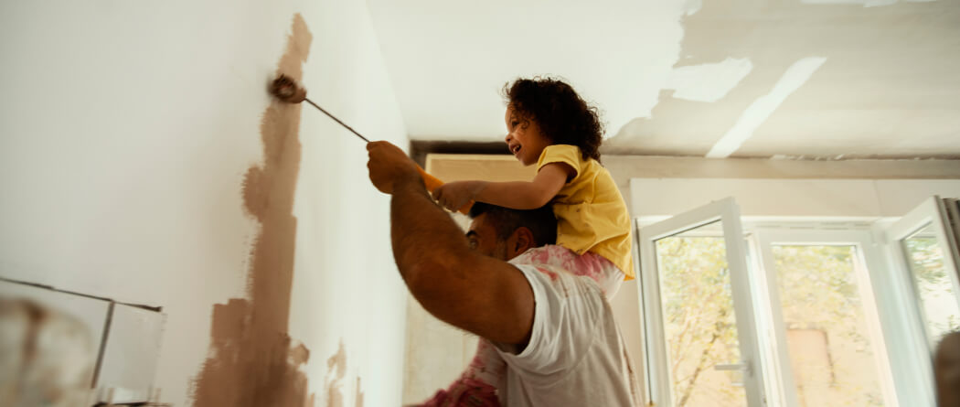 Dad and kid painting a wall in a recently renovated room