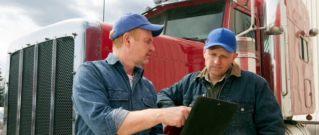 men talking in front of semi