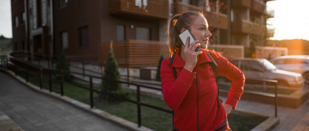 woman talking on cell phone in front of apartment