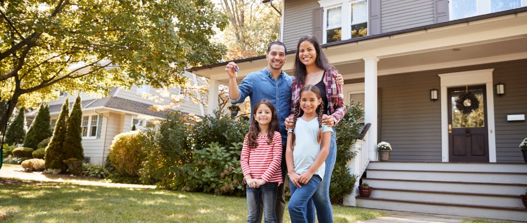 family holding keys to new home